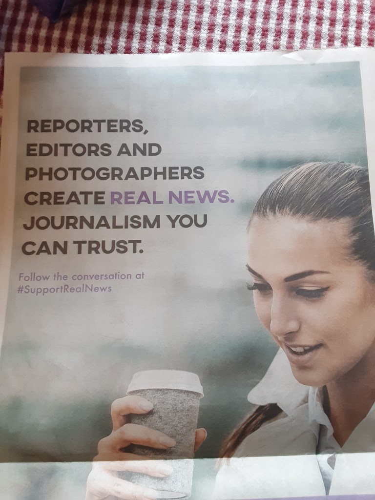 newspaper ad saying, "Reporters, editors and photographers create real news. Journalism you can trust."